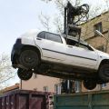 Autowrack, das von einem Kranwagen in einen Container verladen wird