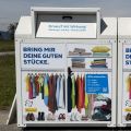 Alttextilcontainer mit bunter Beklebung die mit einem Blick in den Kleiderschrank zeigt, was alles hinein darf: saubere, unbesch&auml;digte und tragbare Kleidung, Heimtextilien sowie paarweise geb&uuml;ndelte Schuhe
