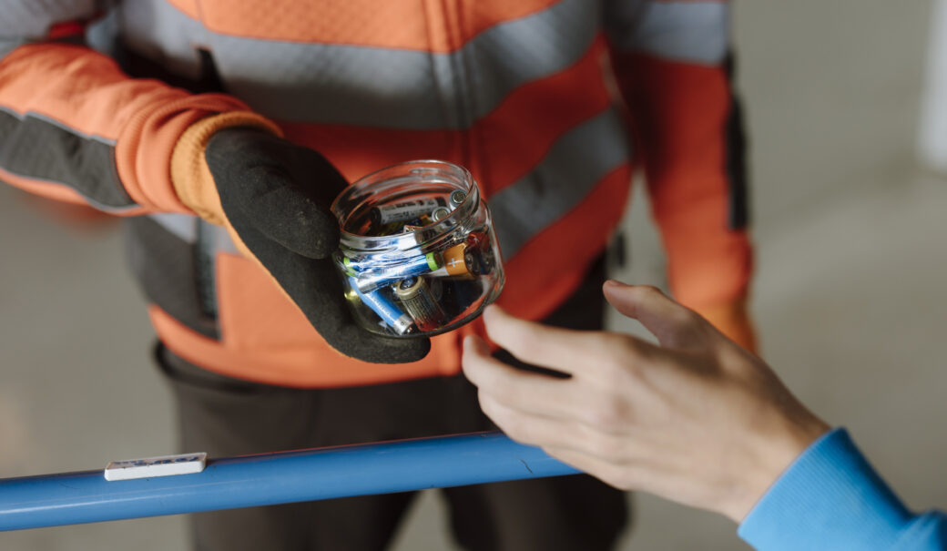 Eine Glasschale gefüllt mit Batterien wird am WSZ an den Mitarbeiter übergeben.